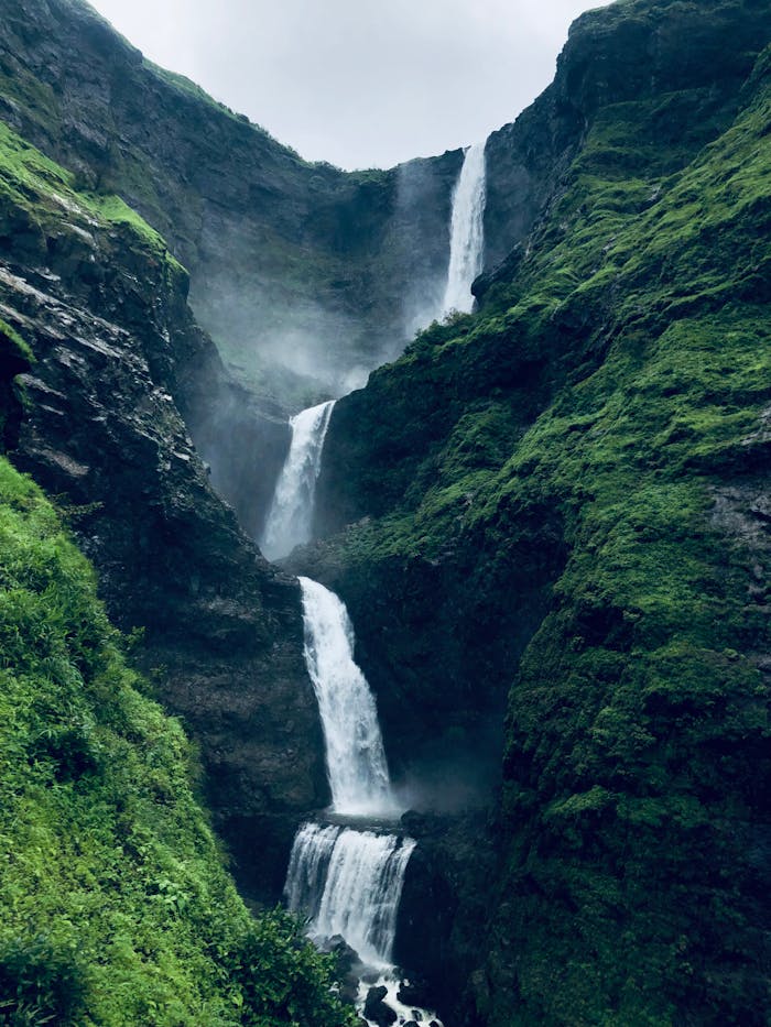 Majestic waterfall cascading through lush greenery in a scenic valley, perfect for nature and travel enthusiasts.